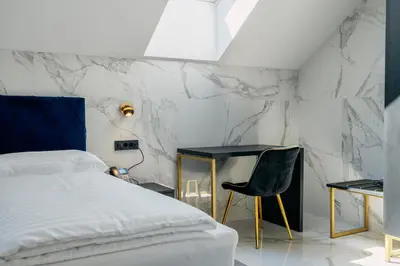 a bedroom with a bed and a desk and a chair at Dvorec Gregorčič in Smarjeske Toplice