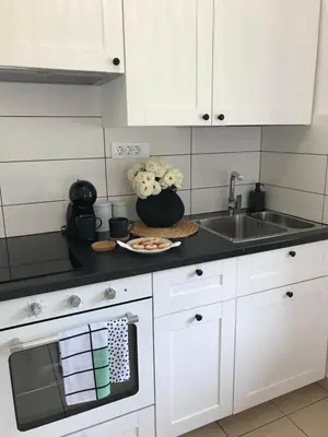 a kitchen with white cabinets and a sink at Apartma 64 in Bovec