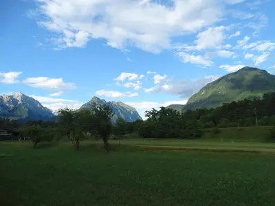 a green field with mountains in the background at Apartma 64 in Bovec