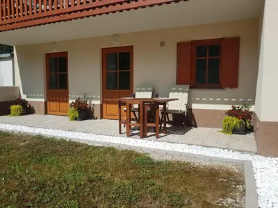 a patio with a table and chairs in a house at Apartma 64 in Bovec