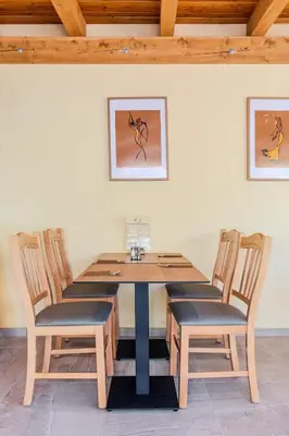 a dining room table with four chairs and a wooden table at Penzion Hosnar, apartma Lev in Bovec