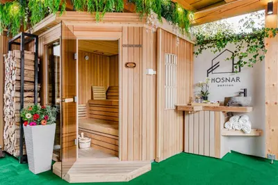 a wooden house with a green floor and plants at Penzion Hosnar, apartma Lev in Bovec