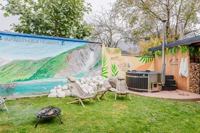a patio with chairs and a grill and a mural at Penzion Hosnar, apartma Lev in Bovec