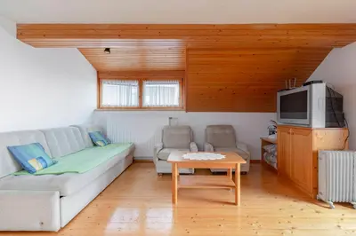 a living room with a couch and a tv at Apartmaji Marko in Bled
