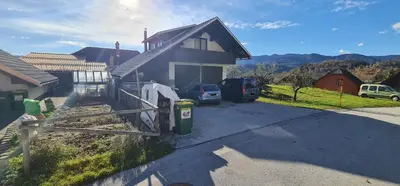 a house with two cars parked in a driveway at Apartmaji Marko in Bled