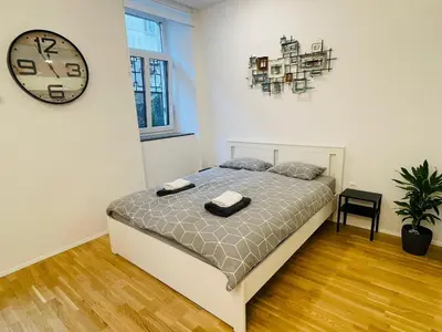 a bedroom with a bed and a clock on the wall at Loni's Place Apartments in Ljubljana