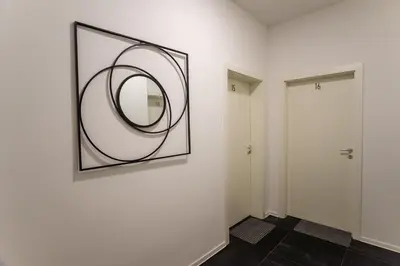 a hallway with a mirror on a wall next to a door at Loni's Place Apartments in Ljubljana