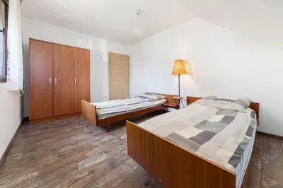 a bedroom with two beds and a cabinet in it at Apartmaji Trstenjak in Rateče
