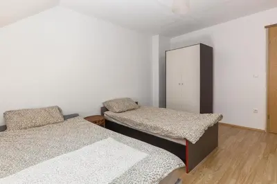 a bedroom with two beds and a cabinet at Apartmaji Trstenjak in Rateče