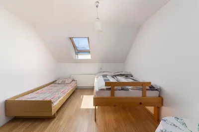 two twin beds in a small room with a window at Apartmaji Trstenjak in Rateče