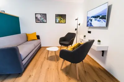 a living room with a couch and two chairs at Garden 13 in Tolmin