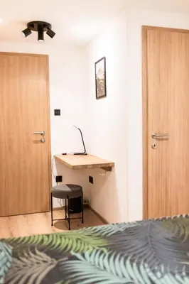 a bedroom with a bed and a desk and a door at Garden 13 in Tolmin
