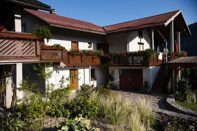 a white house with wooden balconies and flowers at Garden 13 in Tolmin