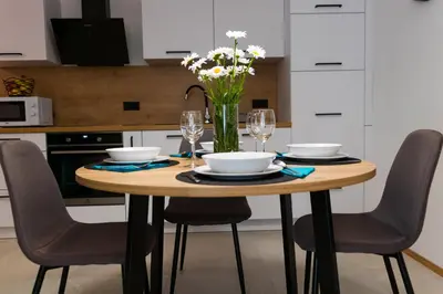 a wooden table with chairs and a vase of flowers at Garden 13 in Tolmin