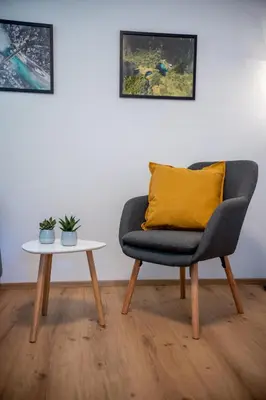 a chair with a yellow pillow and a table at Garden 13 in Tolmin