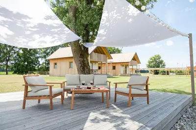 a patio with a table and chairs under a tent at Hiša iz volne in Moravske Toplice