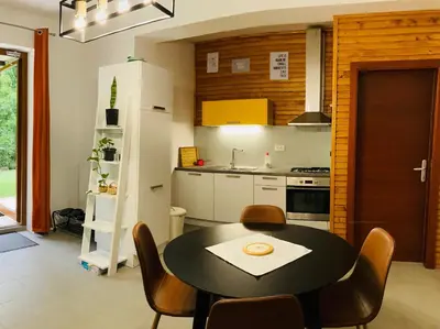 a kitchen with a table and chairs in a room at Family House Apartma in Mozirje