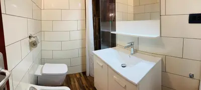 a bathroom with a white sink and a toilet at Family House Apartma in Mozirje