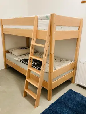 a pair of bunk beds in a room with a ladder at Family House Apartma in Mozirje