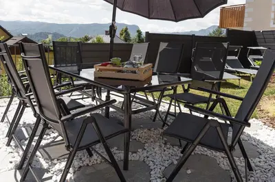 a table and chairs with an umbrella on a patio at ININ APARTMENTS in Bled