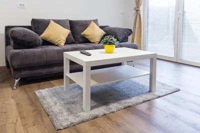 a white coffee table in a living room with a couch at ININ APARTMENTS in Bled