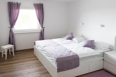 a white bed in a bedroom with a window at ININ APARTMENTS in Bled