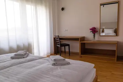 a hotel room with a bed and a desk and a mirror at Hiša na Vrtu in Šenčur
