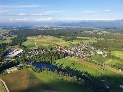 an aerial view of a small town with a lake at Hiša na Vrtu in Šenčur
