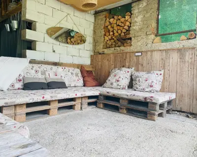 a patio with two wooden benches with pillows at Garden Apartments Bled in Bled