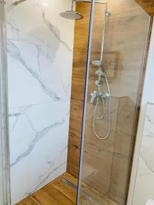 a shower in a bathroom with white marble at Garden Apartments Bled in Bled