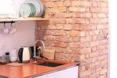 a kitchen with a brick wall and a sink at Garden Apartments Bled in Bled