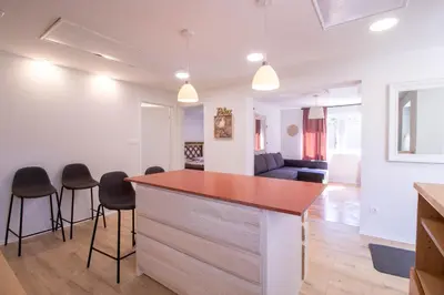 a kitchen and living room with a counter and stools at Garden Apartments Bled in Bled
