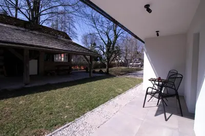 a patio with two chairs on the side of a house at Garden Apartments Bled in Bled