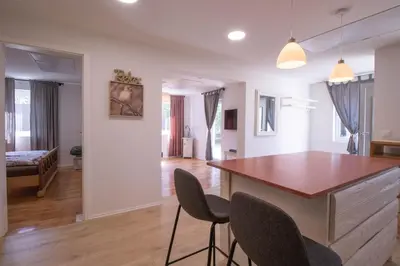 a kitchen and living room with a table and chairs at Garden Apartments Bled in Bled