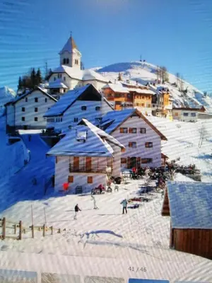 a group of people skiing in the snow in a town at Žbogar in Rateče