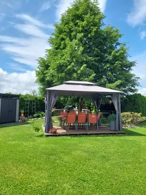 a gazebo with a table and chairs in a yard at Studio apartma Žirovnik in Cerklje na Gorenjskem