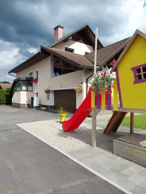 a playground in front of a house with a slide at Studio apartma Žirovnik in Cerklje na Gorenjskem