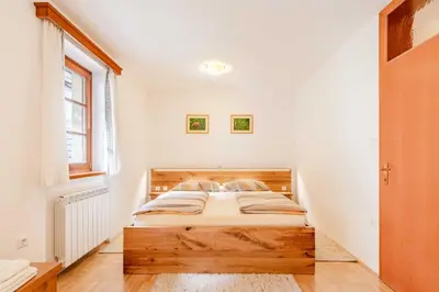 a bedroom with a wooden bed in a room at Apartma Miranda in Log pod Mangartom