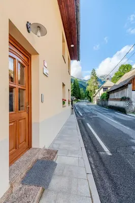 a building with a door on the side of a street at Apartma Miranda in Log pod Mangartom