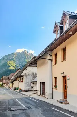 a street in a town with mountains in the background at Apartma Miranda in Log pod Mangartom