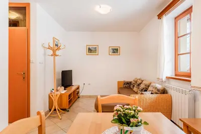 a living room with a table and a couch at Apartma Miranda in Log pod Mangartom