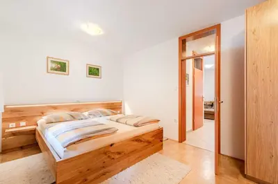 a bedroom with a bed with a wooden headboard at Apartma Miranda in Log pod Mangartom