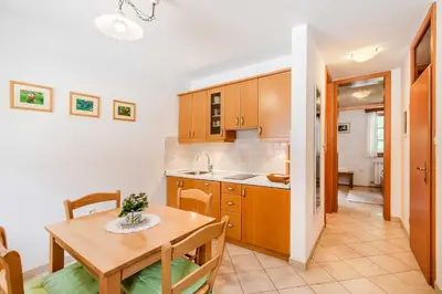 a kitchen and dining room with a wooden table at Apartma Miranda in Log pod Mangartom