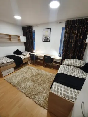 a dorm room with two beds and a desk at RAILWAY STATION CITY MODERN APARTMENT in Maribor