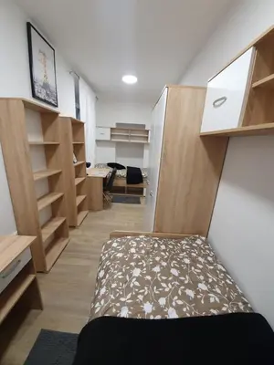 a room with a bed and wooden shelves at RAILWAY STATION CITY MODERN APARTMENT in Maribor