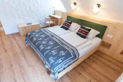 a bedroom with a large bed with blue and white sheets at Guesthouse & Camping Danica Bohinj in Bohinj