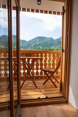 a room with a balcony with a view of mountains at Guesthouse & Camping Danica Bohinj in Bohinj