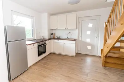 a kitchen with white cabinets and a stainless steel refrigerator at Apartment Organic Farm Hvadnik in Tržič
