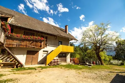 a house with a balcony with flowers on it at Apartment Organic Farm Hvadnik in Tržič