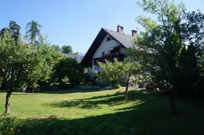 a house on a hill with trees in front of it at Apartma Tanya Bled in Bled
